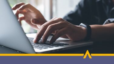 Mężczyzna pracuje przy laptopie, dłonie znajdują się na klawiaturze